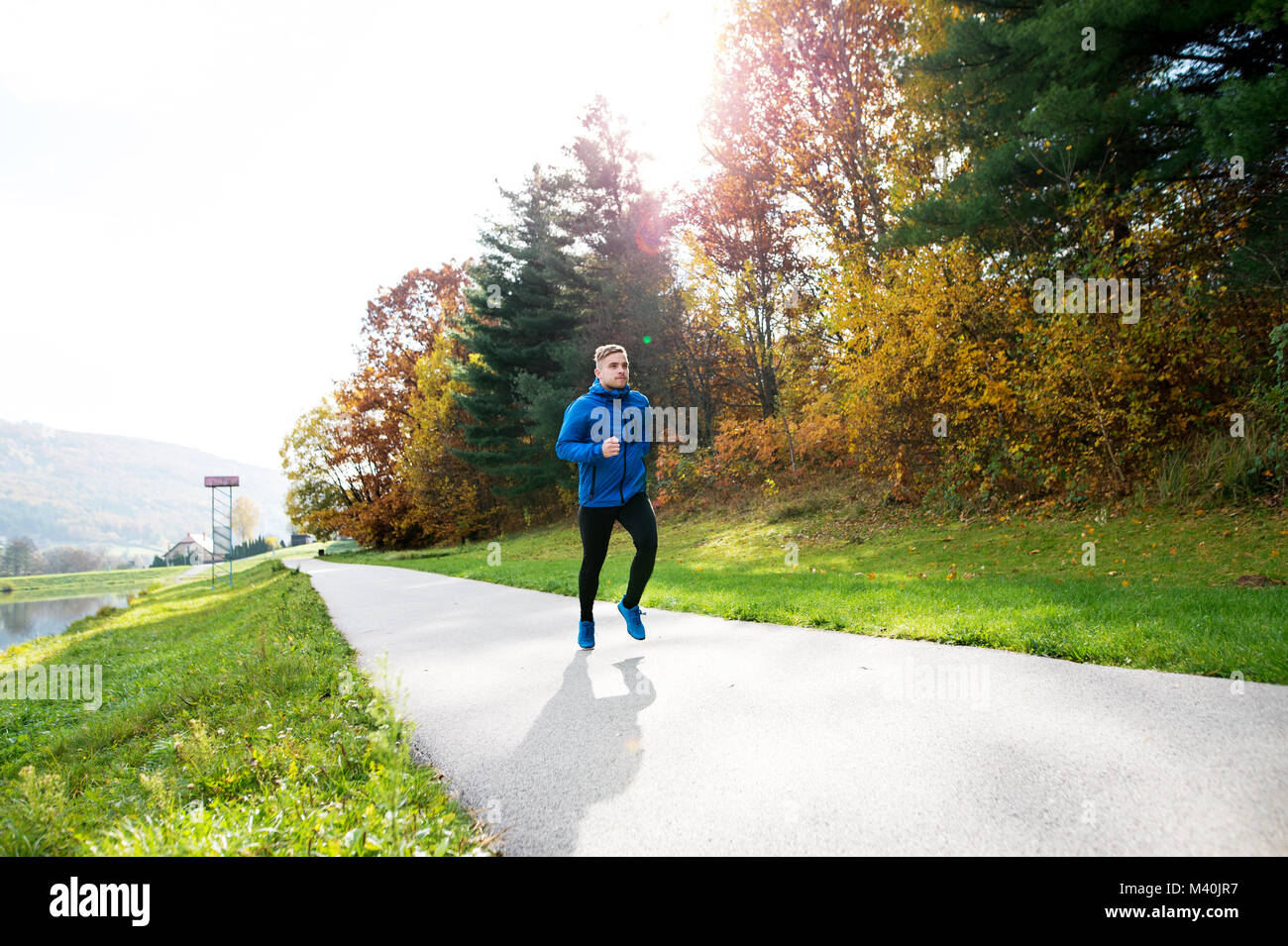 Junge Athleten im Park im bunten Herbst Natur ausgeführt. Stockfoto