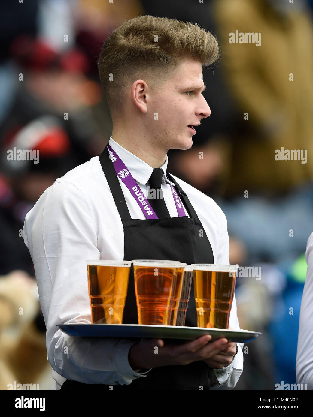 Ein Kellner mit einem Tablett mit Bier vor sechs Nationen an den BT Stadion Murrayfield, Edinburgh International Rugby. Stockfoto