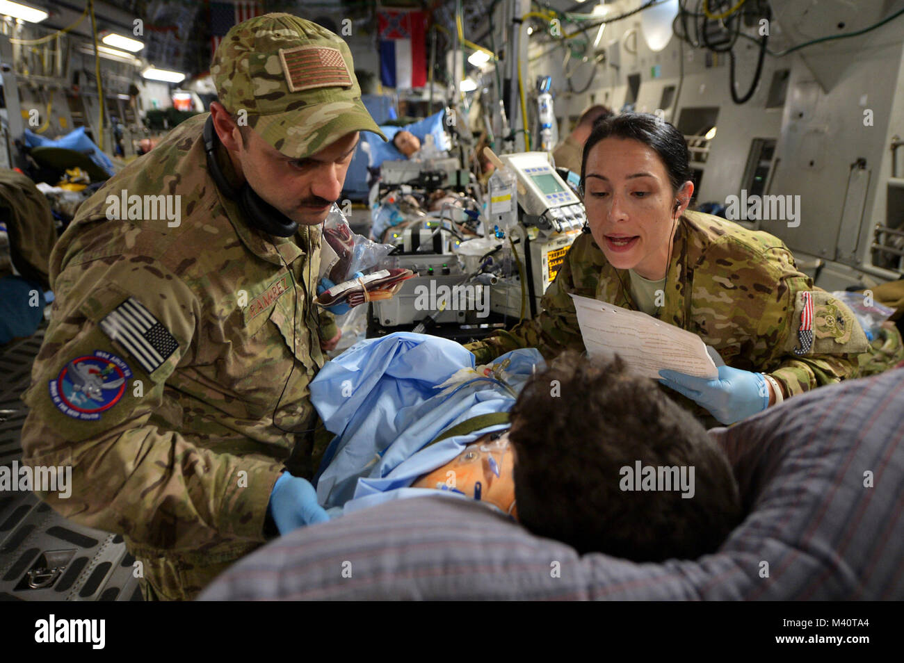 Kapitän Mario Ramirez und Kapitän Suzanne Morris, Mitglieder der 455th Expeditionary Aeromedical Evacuation Squadron Critical Care Air Transport Team, bestätigen Sie die Identität des Patienten und bereiten eine Bluttransfusion während eines Aeromedical evacuation Flug vom Flughafen Bagram, Afghanistan zu verwalten. Eine CCATT Crew besteht aus einem Arzt, Intensivpflege Krankenschwester und einem atmungstherapist. Damit ist es möglich, sich zu bewegen, um dort schwer verletzte oder schwer Kranken servicemembers durch die Luft. (U.S. Air Force Foto/Älterer Flieger Chris Willis) Nach der Schlacht-010 von AirmanMagazine Stockfoto