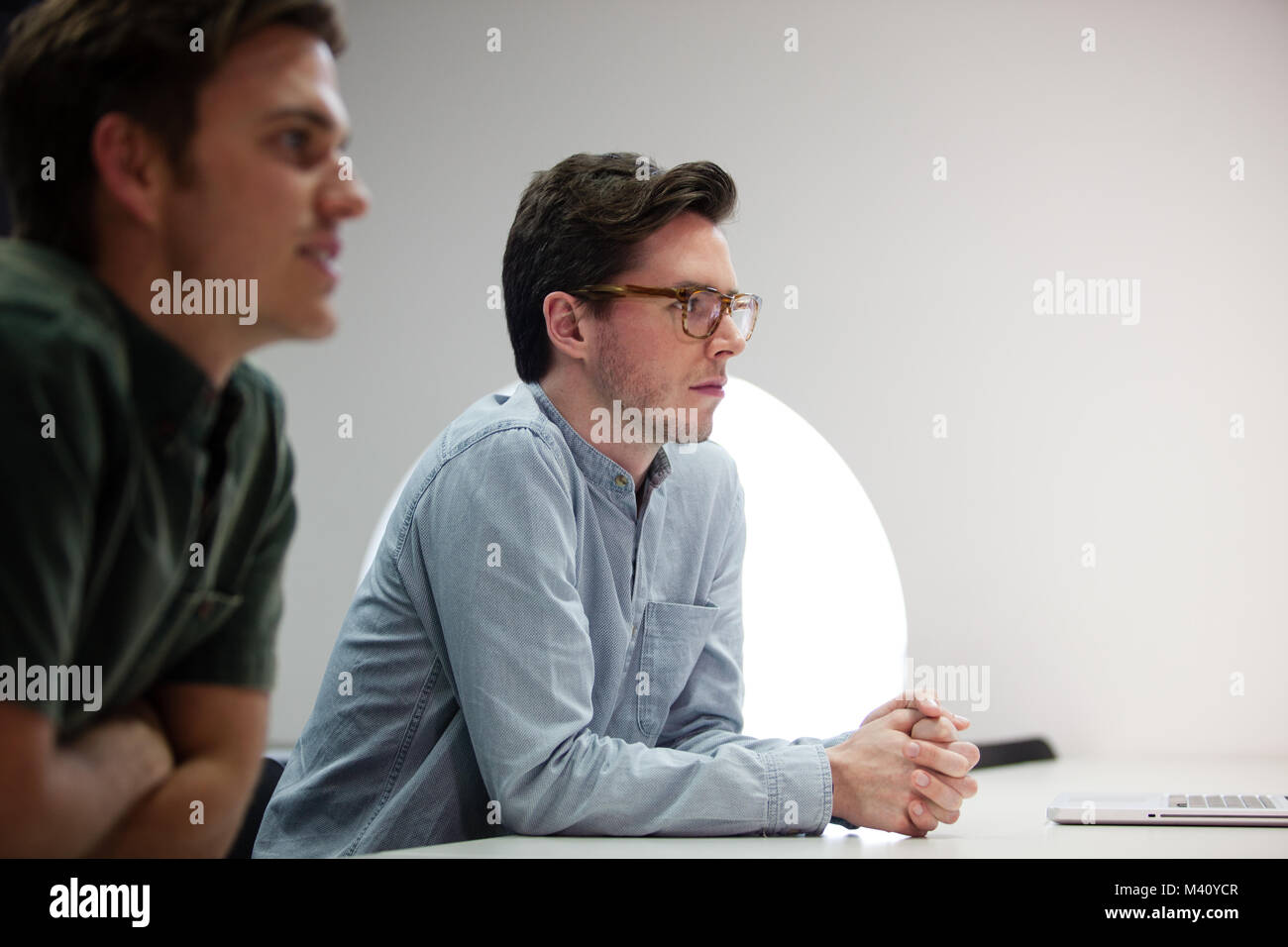 Zwei Geschäftsleute hören in einer Sitzung Stockfoto