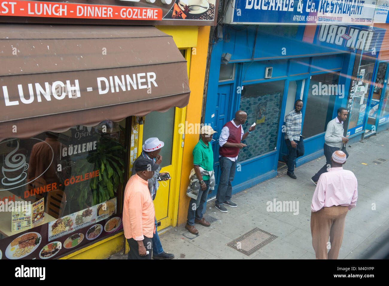 London, Vereinigtes Königreich. Kunden aus dem Horn von Afrika außerhalb eines Cafe, Seven Sisters Road. Szene aus dem Bus. Stockfoto