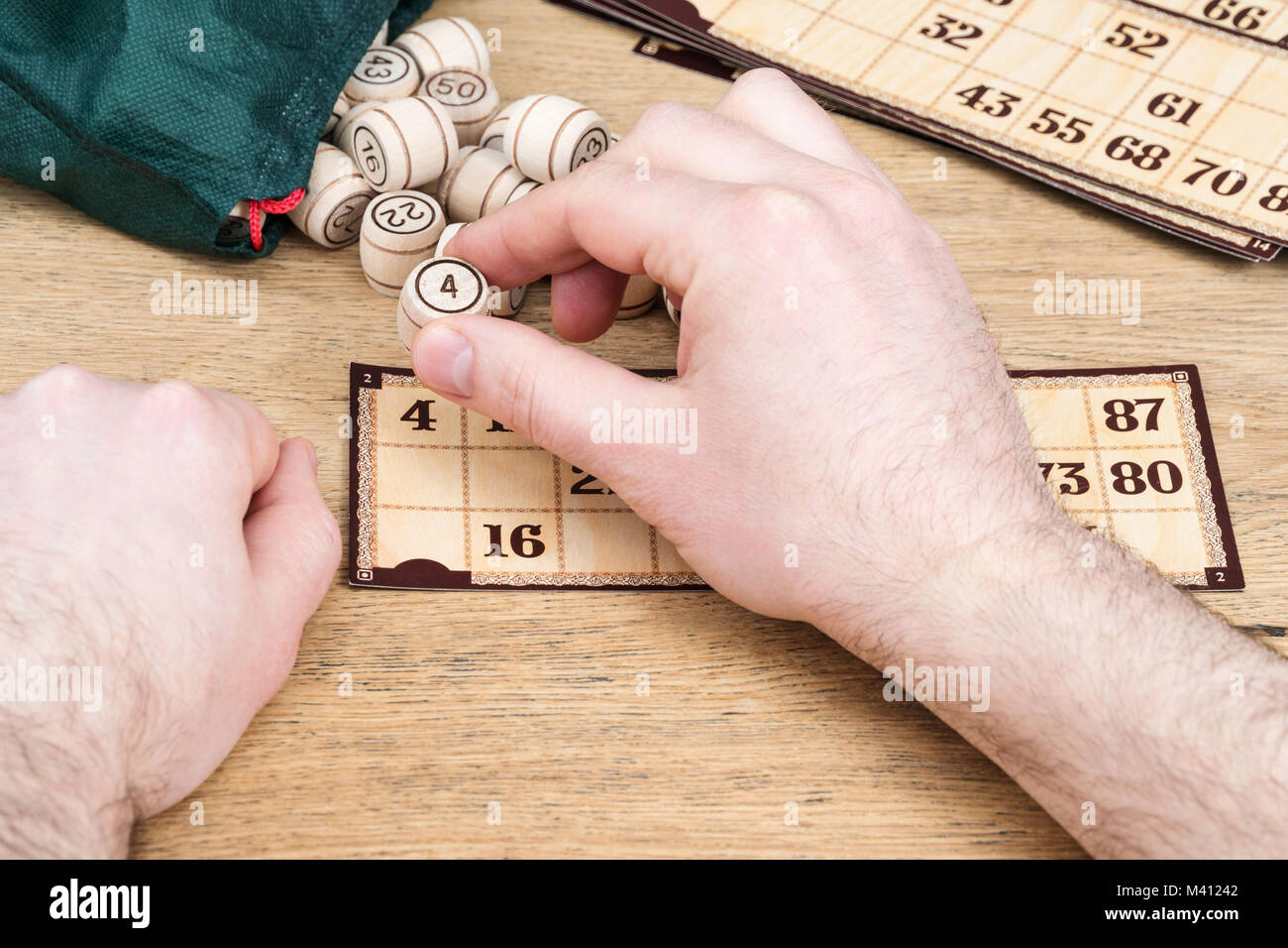 Männliche Hände spielen im Lotto schließen die gefallenen Abbildung auf der Karte, closeup
