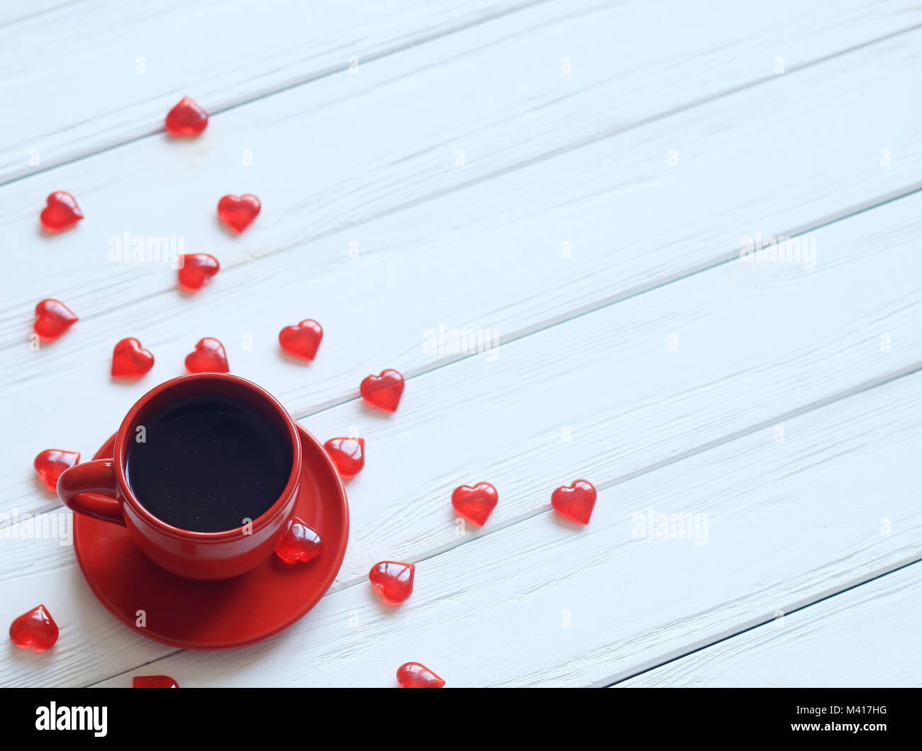 Ansicht von oben. die Kaffeetasse und Geschenkbox mit roter Schleife auf einen hölzernen Tisch. Stockfoto