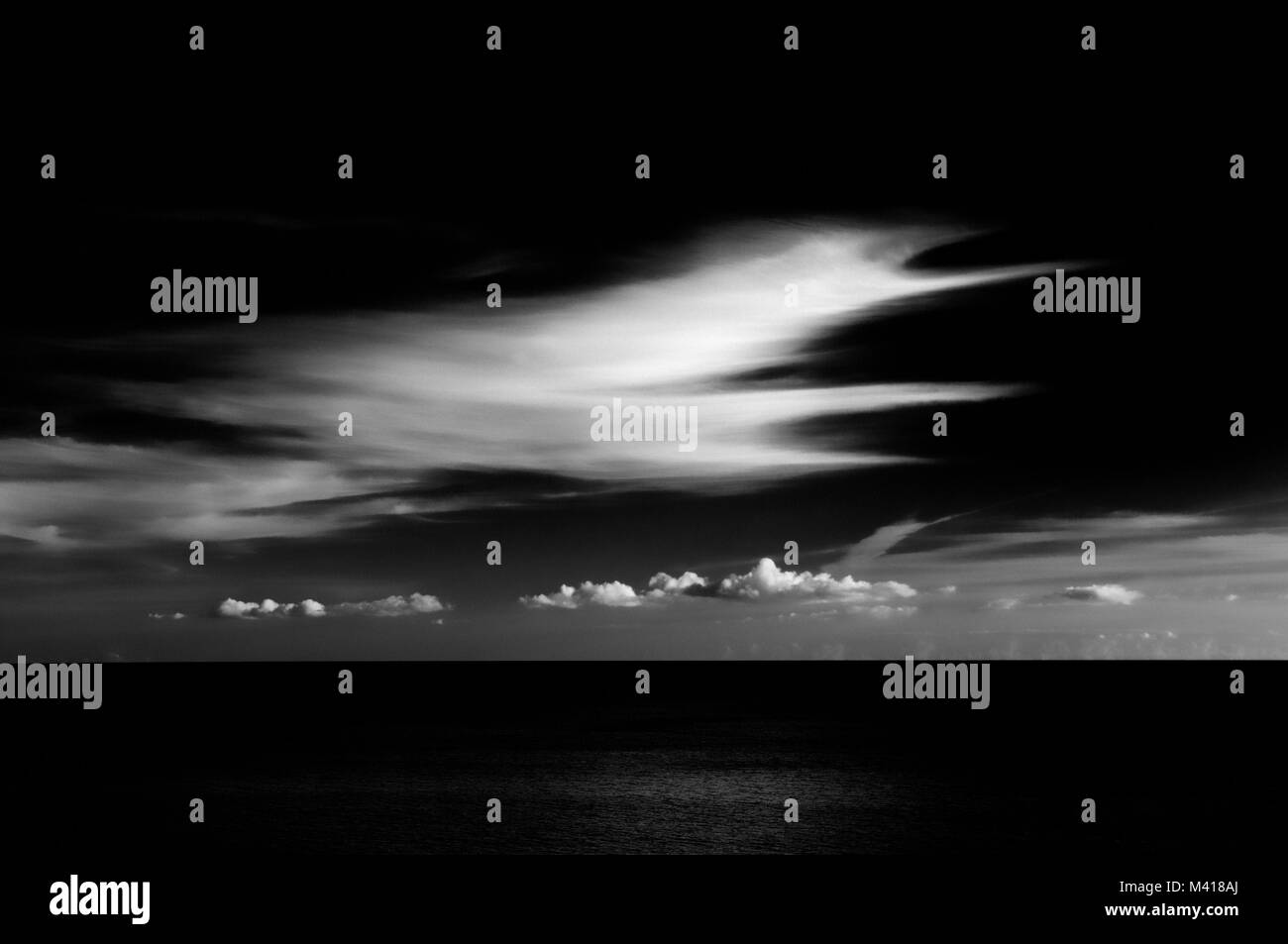 Zeitgenössische Kontrastreiche Schwarzweiß-Bild von markanten Wolkenformationen über eine ruhige See. Stockfoto