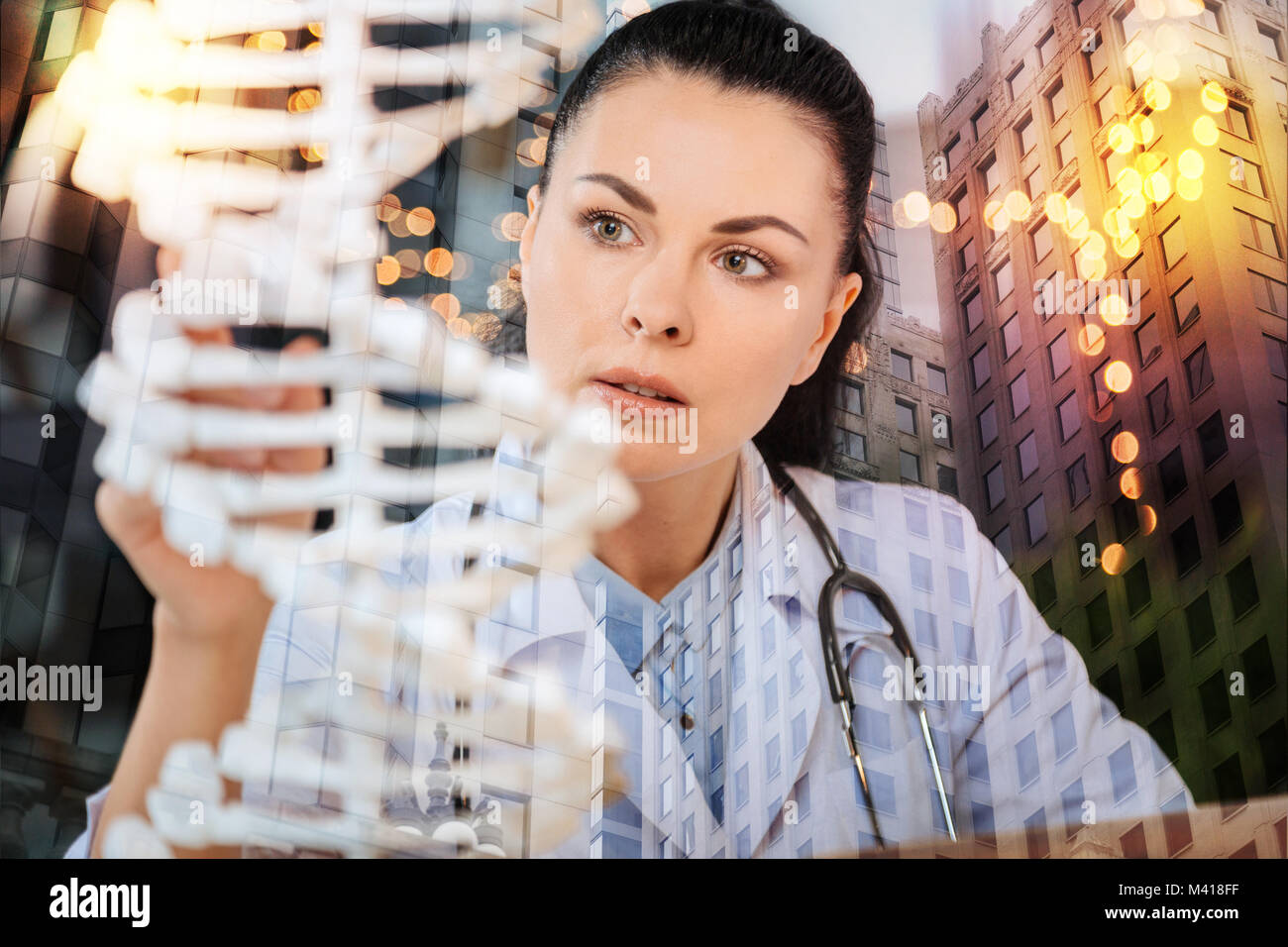 Ernsthafte medizinische Arbeiter suchen aufmerksam während des Studiums DNA Stockfoto