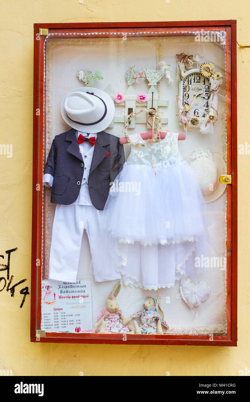 Rethymno, Griechenland - 3. Mai 2016: Miniatur Hochzeit Anzug und Brautjungfer Kleid auf Namensschild von Bridal Salon. Kunst auf touristische Routen von Stadt Rethymn Stockfoto