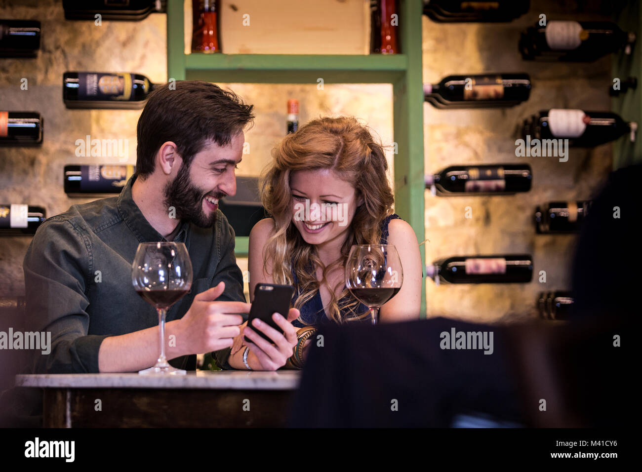 Junges Paar an einem Smartphone auf einem Datum suchen Stockfoto
