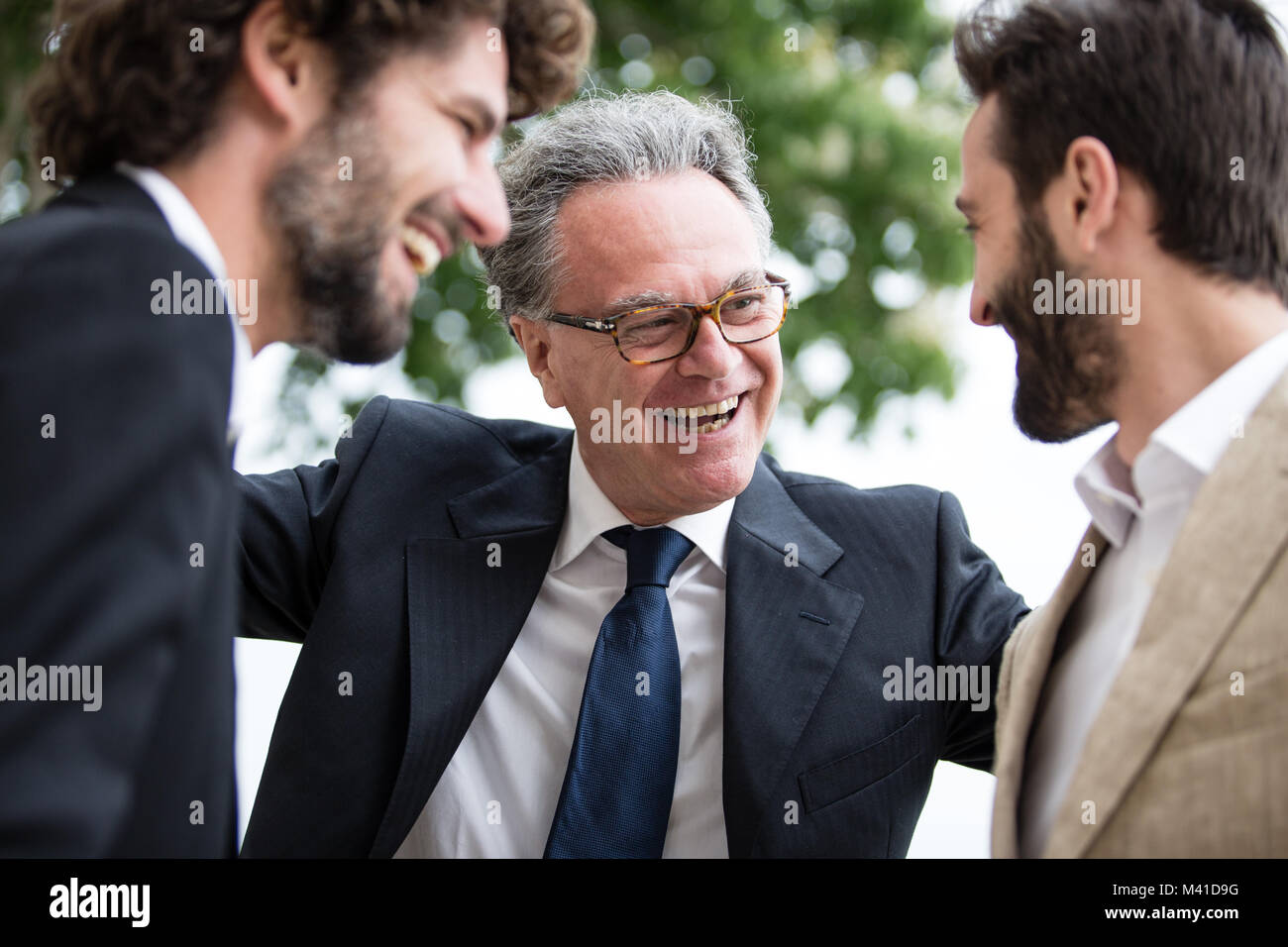 Älterer Mann mit seinen zwei erwachsenen Söhnen Stockfoto
