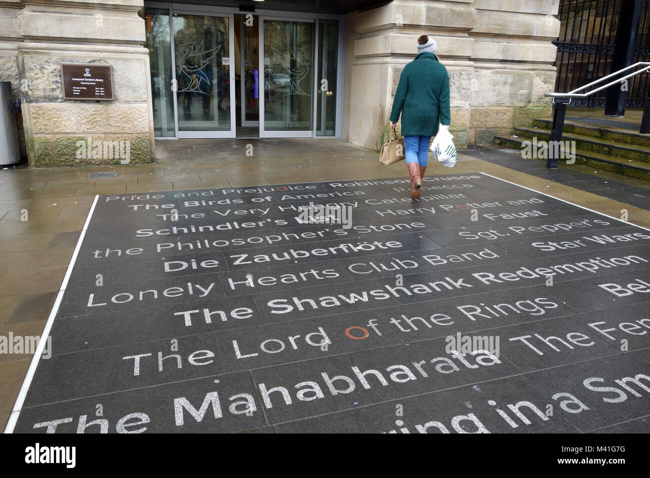 Frau mit Shopper zu Fuß in Richtung der Eingang zu Liverpool Central Library. Stockfoto