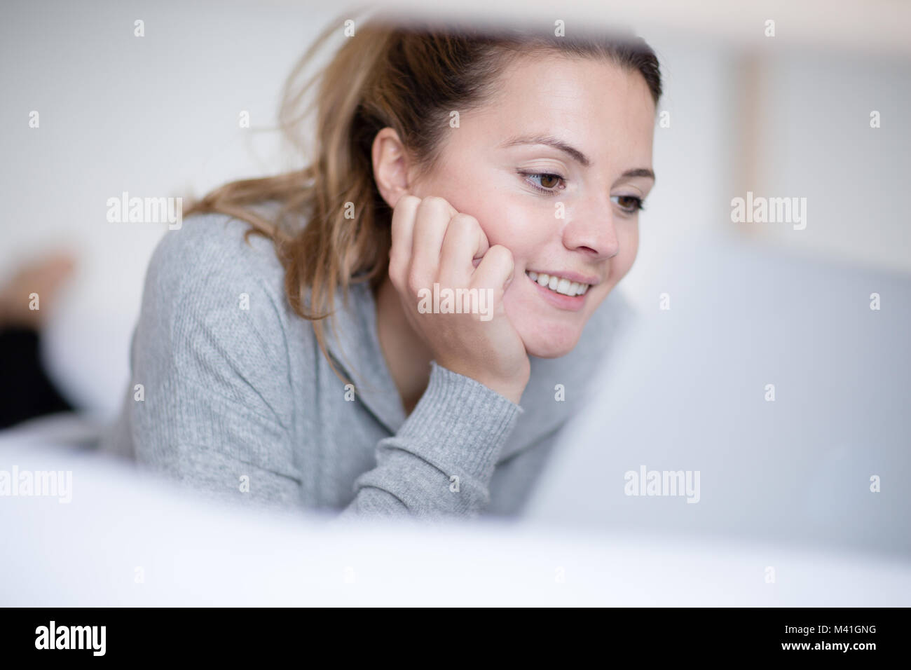 Junge erwachsene Frau Lesen im Bett Stockfoto