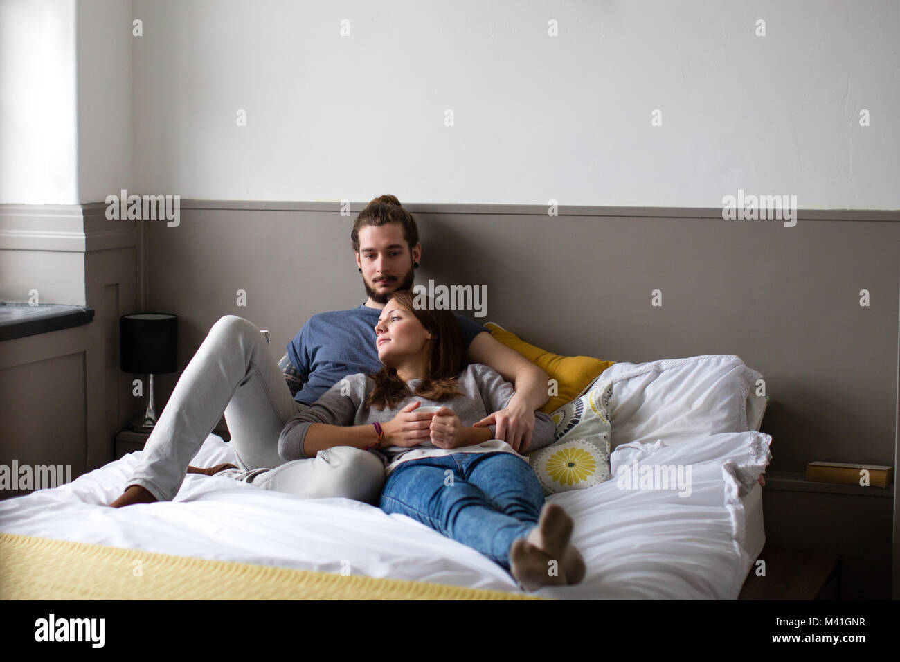 Junges Paar mit Kaffee im Bett Stockfoto
