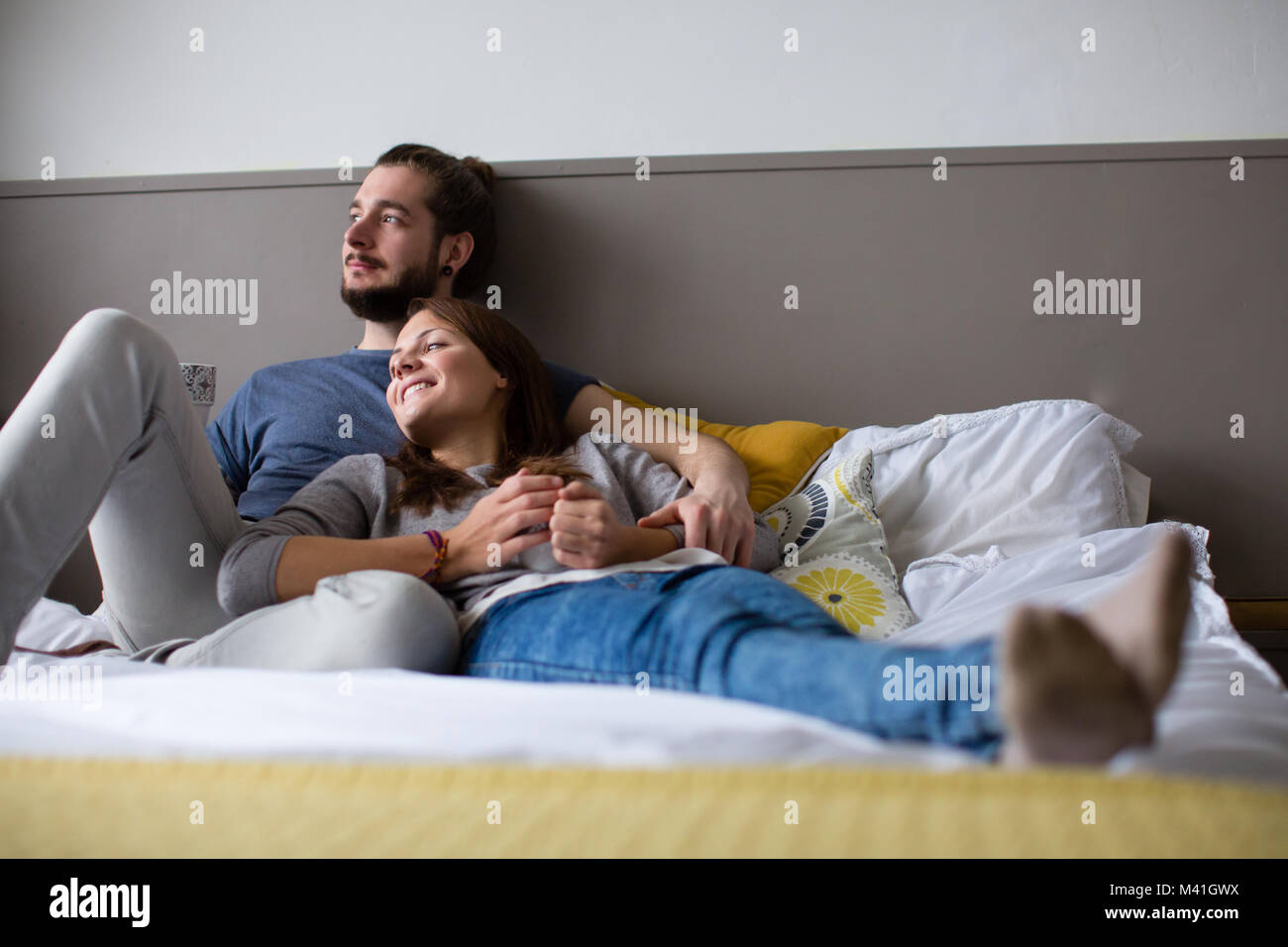 Junges Paar mit Tee im Bett Stockfoto