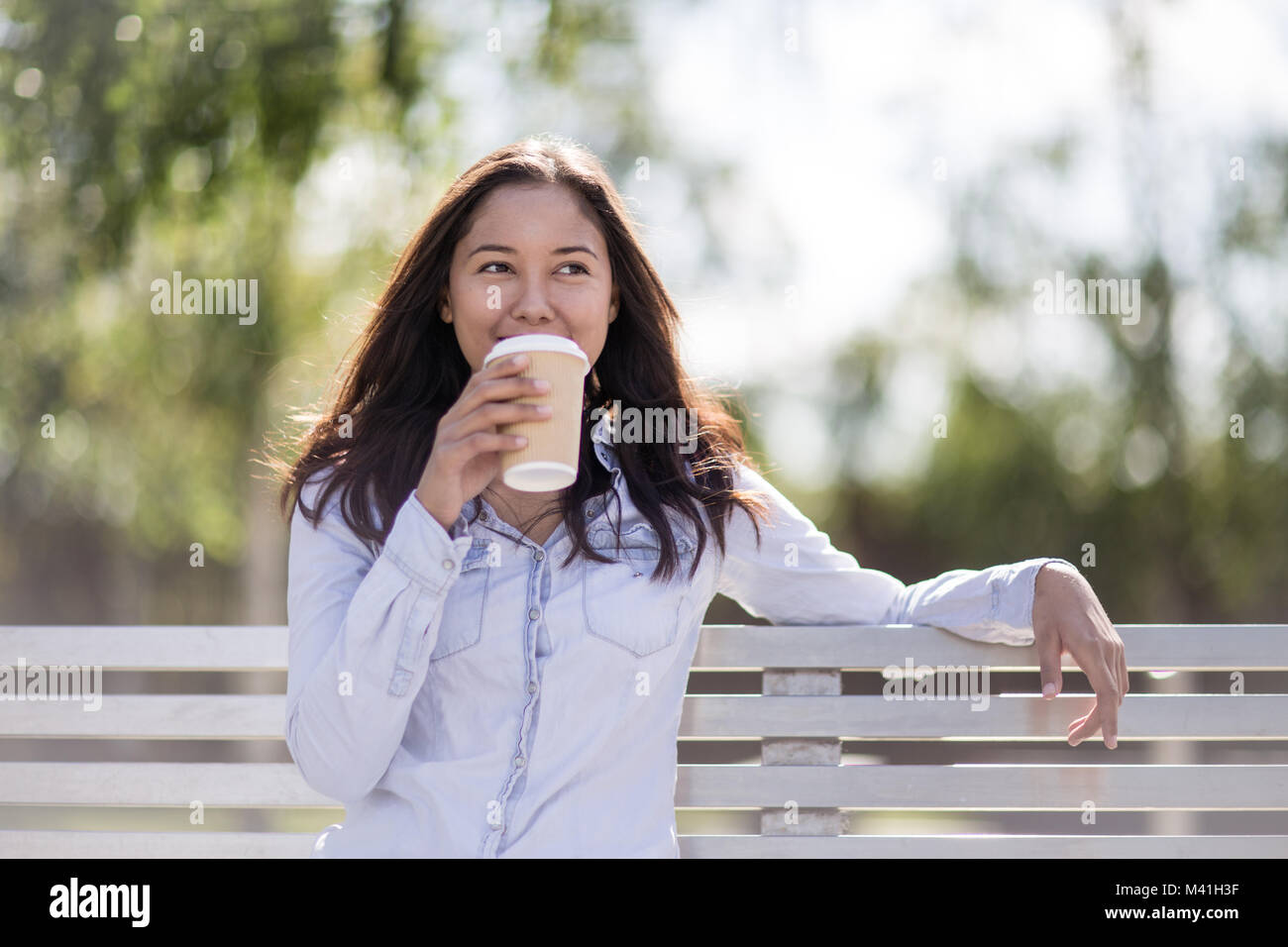 Frau sitzt auf der Bank im park Stockfoto