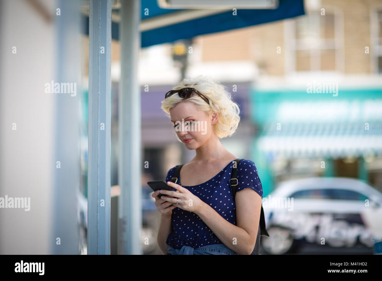 Junge erwachsene Frau mit einem Smartphone beim Einkaufen Stockfoto