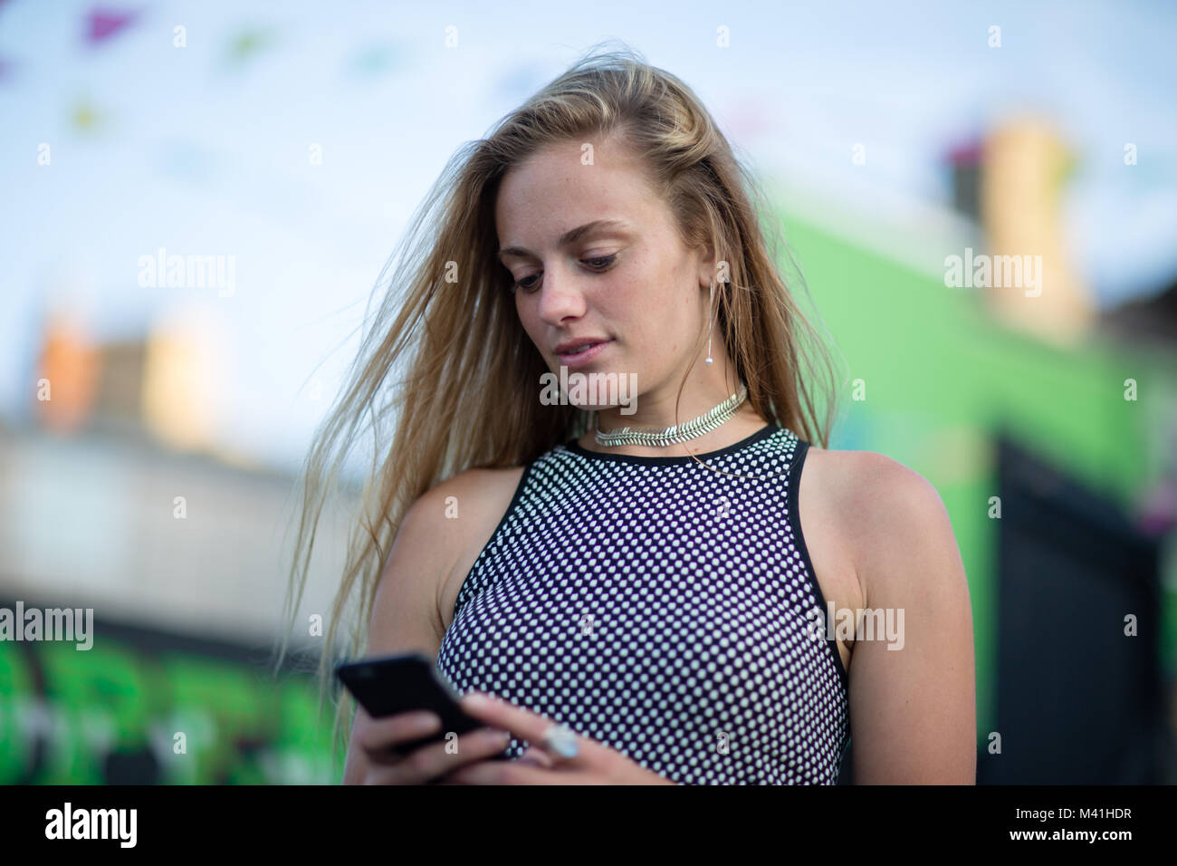 Junge weibliche auf dem Smartphone an einem Markt im Freien Stockfoto
