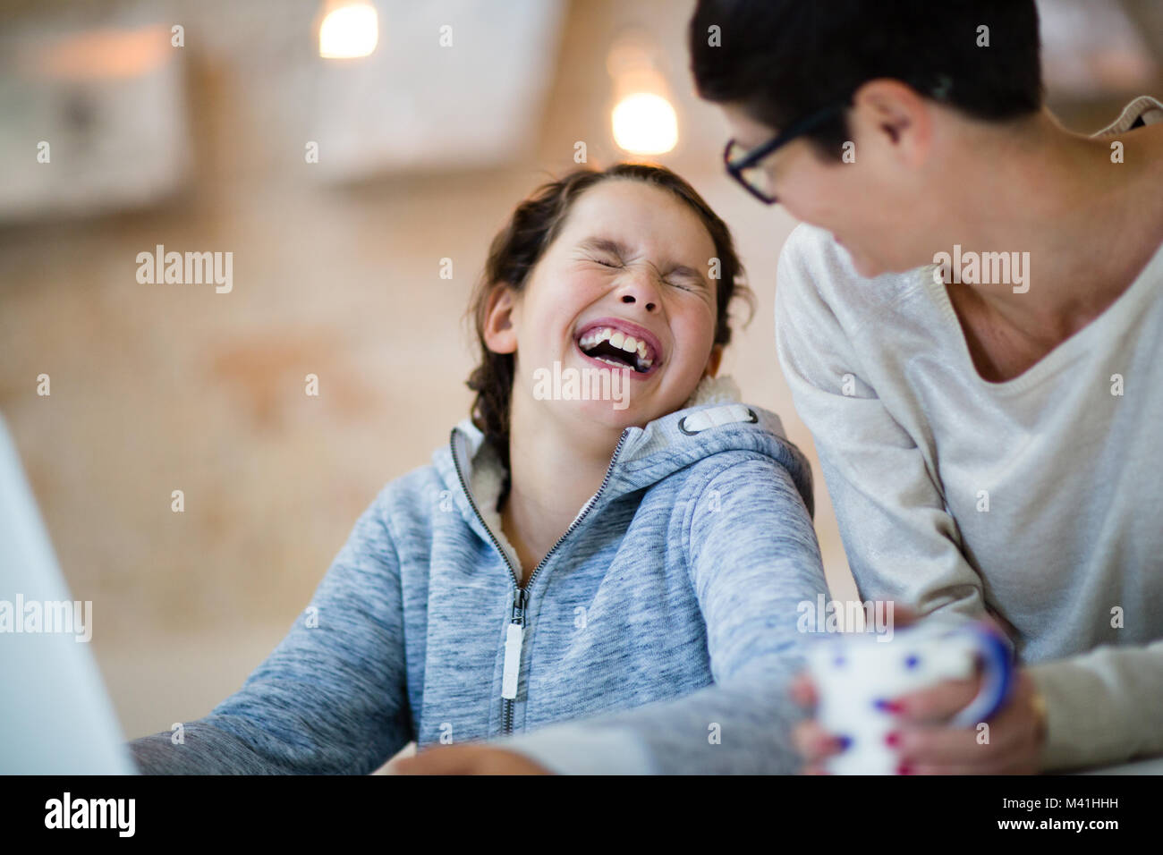 Tochter lachend mit Mama zu Hause Stockfoto