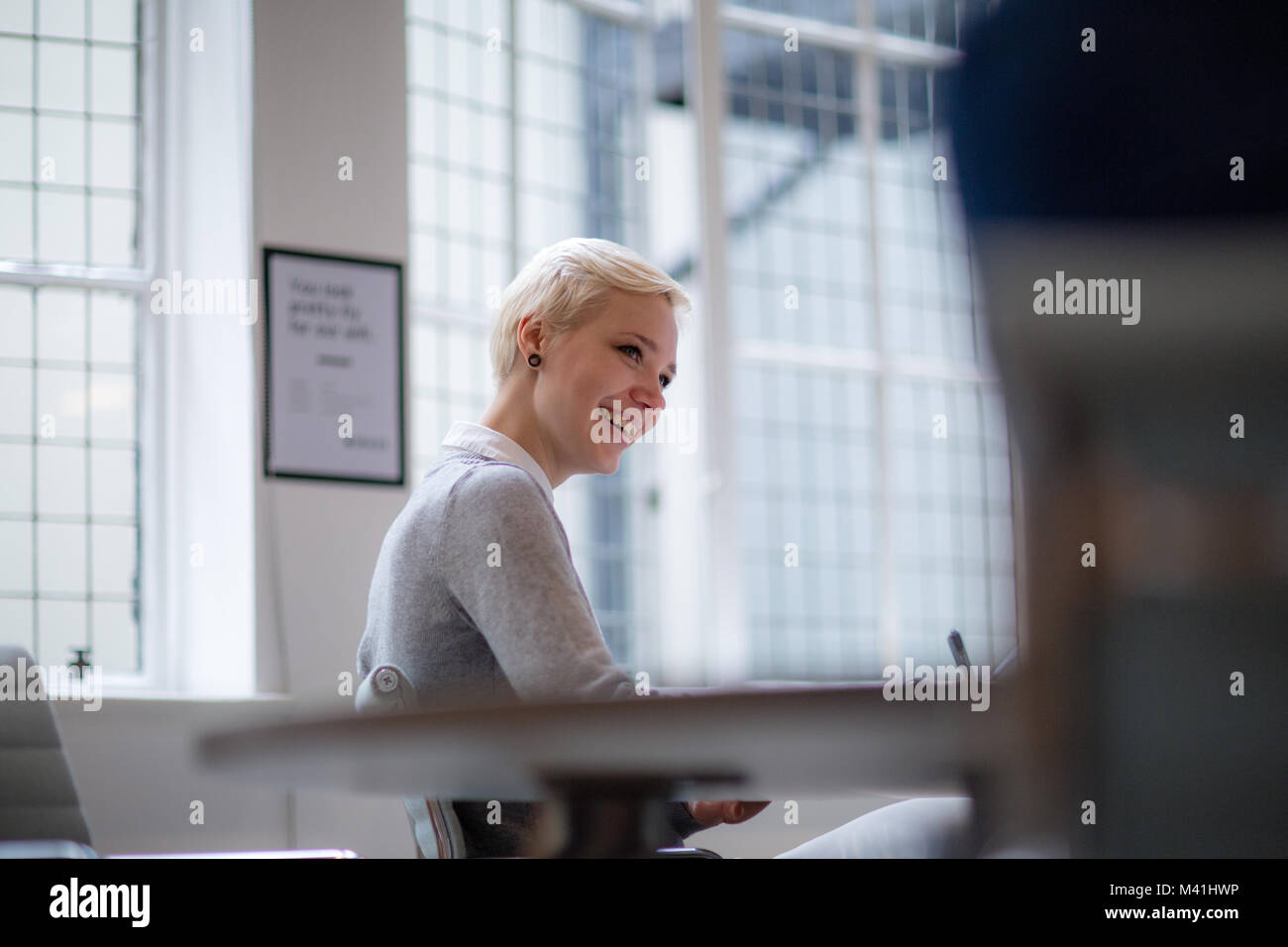 Junge weibliche Geschäftsfrau Notizen in Sitzung Stockfoto
