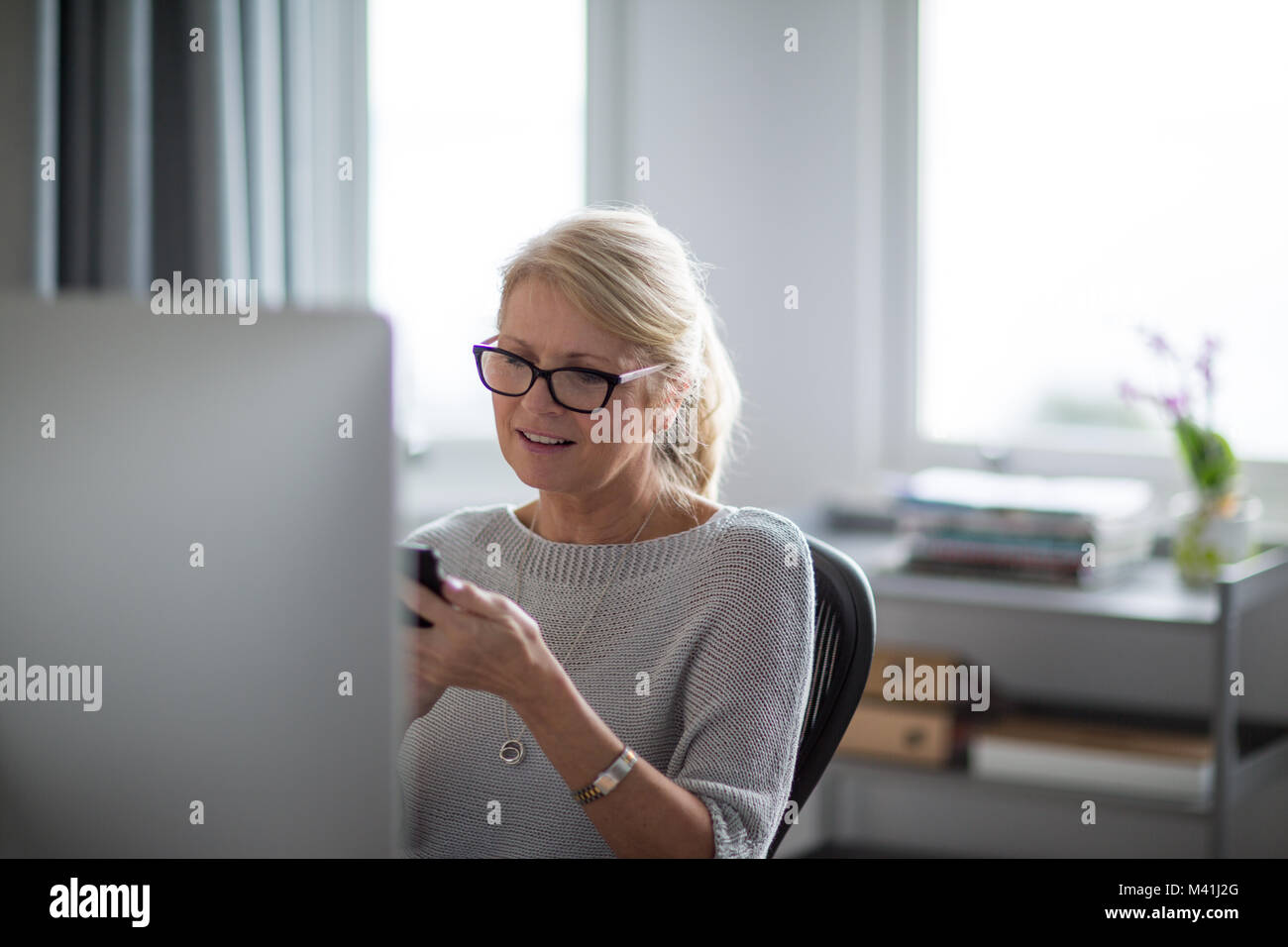 Reife Geschäftsfrau mit Smartphone Stockfoto