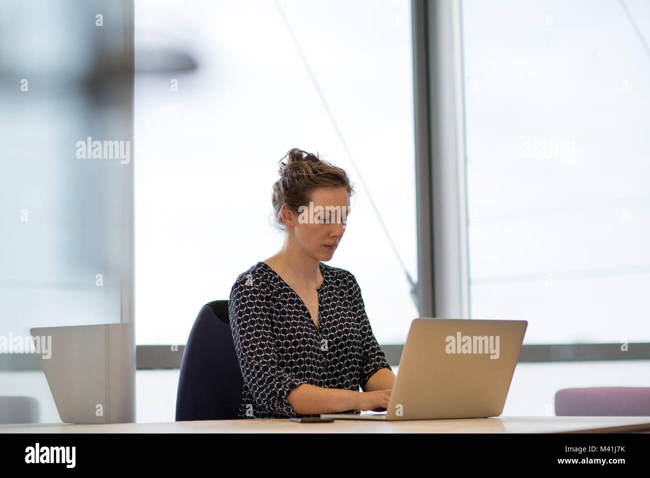Weibliche Mitarbeiter im Büro auf Laptop Stockfoto