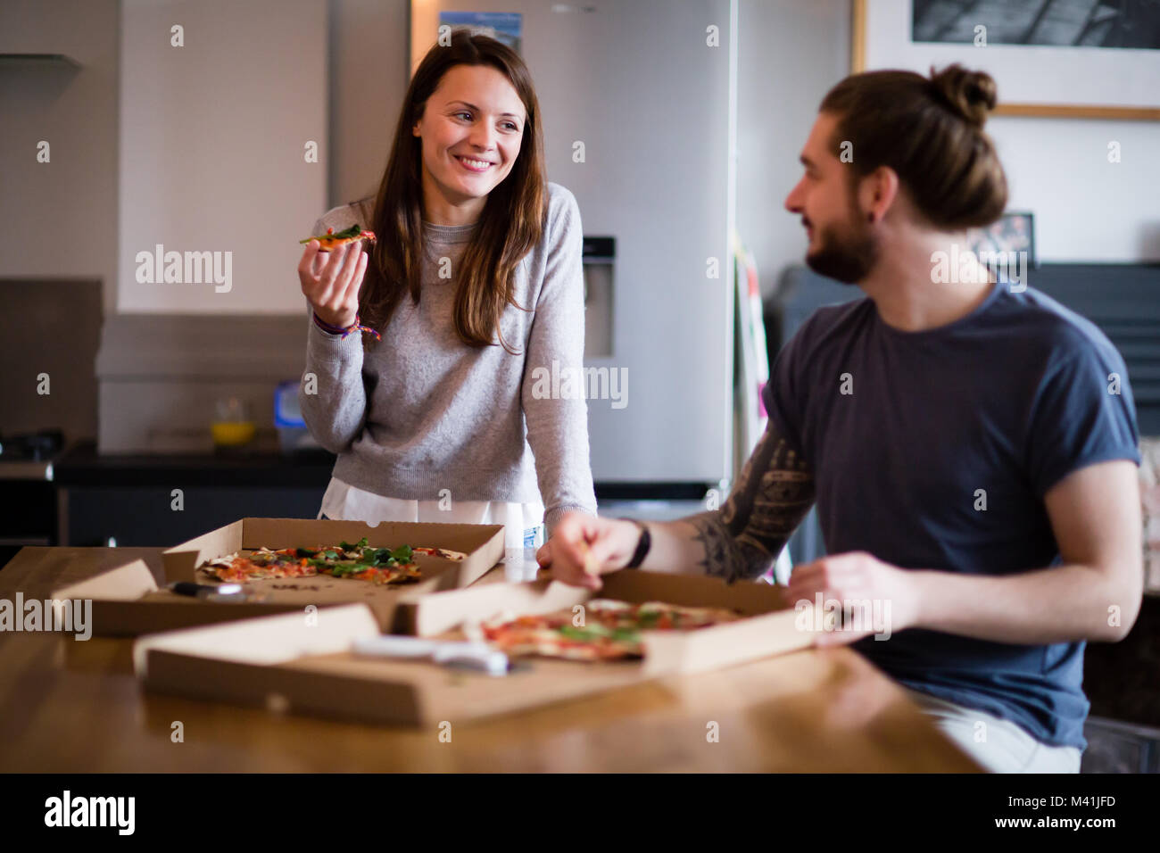Junges Paar essen Pizza zum Mitnehmen zu Hause Stockfoto
