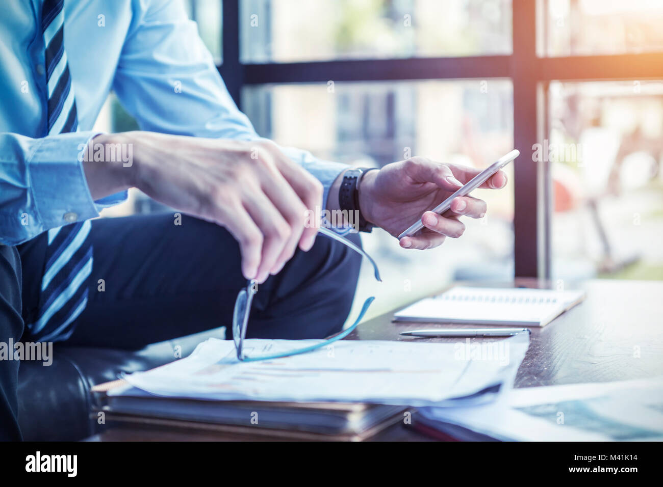 Geschäftsmann mit mobilen E-Mails bei der Arbeit im Büro. Moderne Technologie und Geschäftsidee. Stockfoto