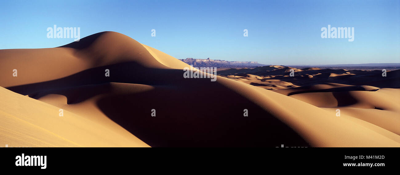 Libyen, Sahara, die Sanddünen der Tanezouft in der Nähe der Oase Ghat, das Akakus-massiv im Hintergrund Stockfoto Libyen, Sahara, die Sanddünen der Tanezouft in der Nähe der Oase Ghat, das Akakus-massiv im Hintergrund Stockfoto