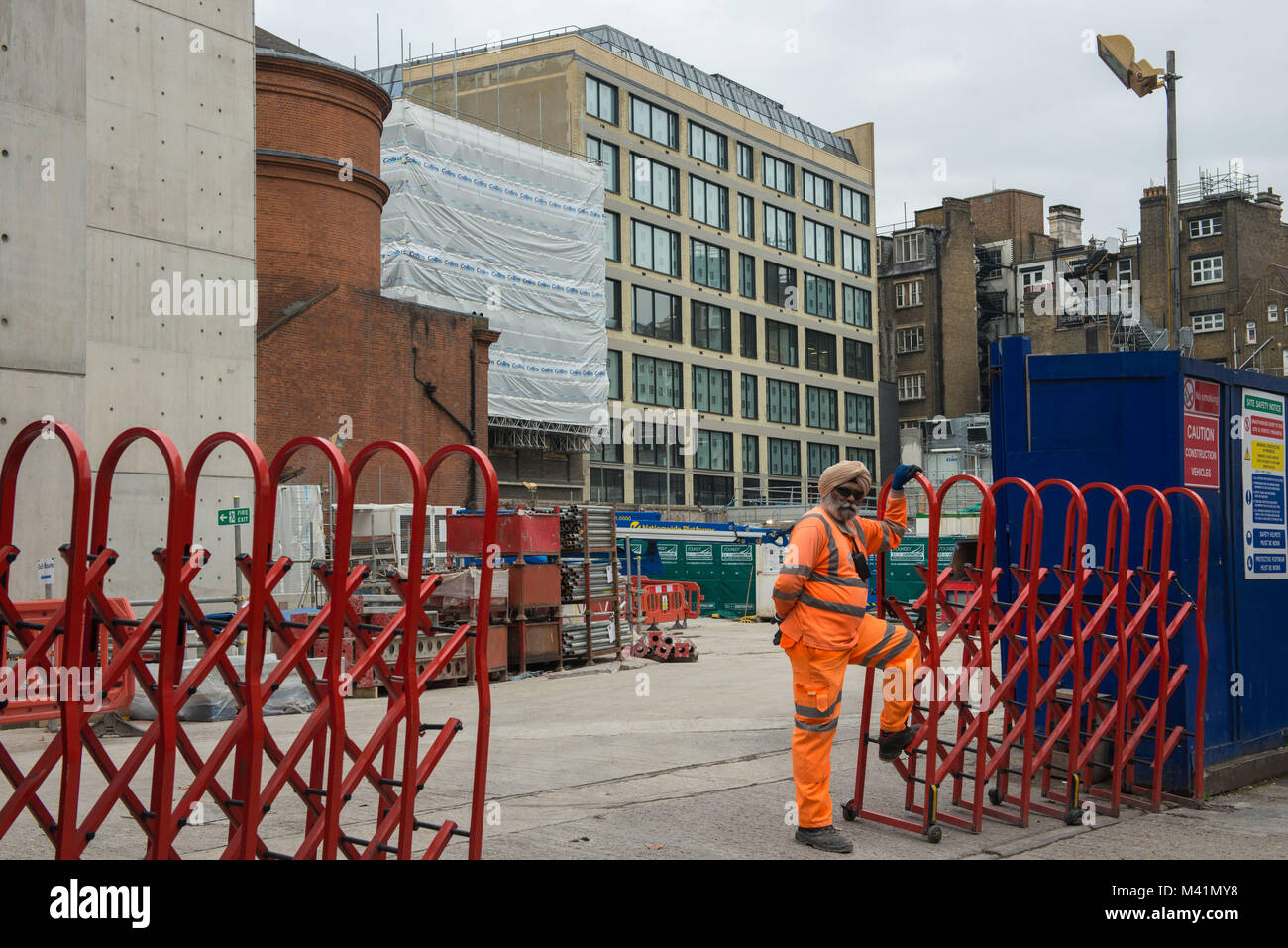 London, Vereinigtes Königreich. Indische Arbeiter außerhalb einer Baustelle, Tottenham Court Road. Stockfoto