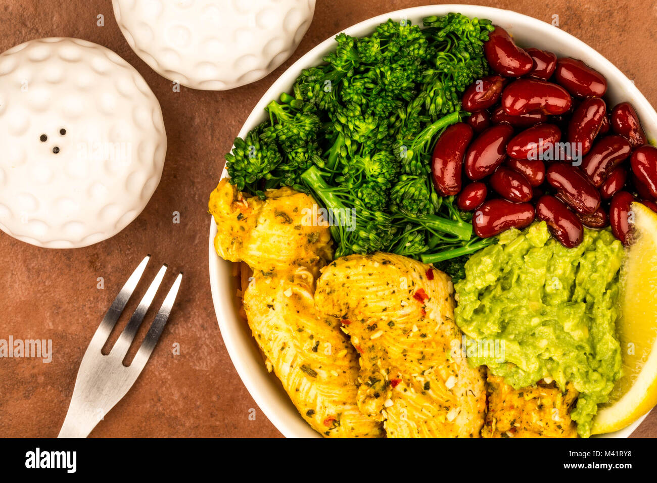 Im Hawaiianischen Stil Huhn und Gemüse Poke Schüssel gegen eine rote Fliese Hintergrund Stockfoto