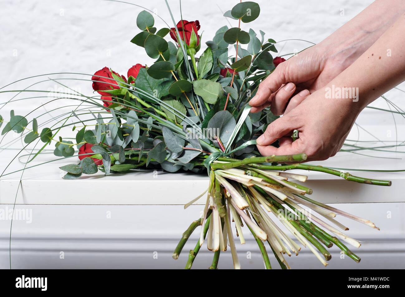 Buches von Blumen für einen besonderen Anlass wie Valentinstag angeordnet wird. Frau trimmen die Stiele der Blumen nach anordnen. Stockfoto