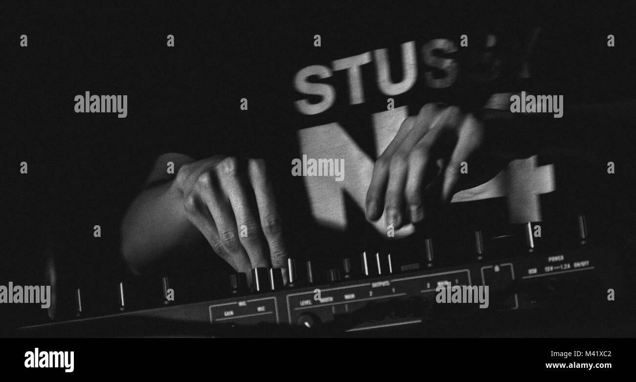 Mann spielt elektronische Musik für ein Publikum in Schwarz und Weiß. Stockfoto