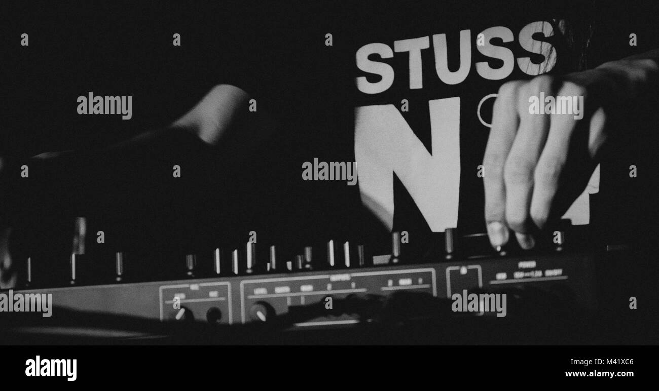 Mann spielt elektronische Musik für ein Publikum in Schwarz und Weiß. Stockfoto