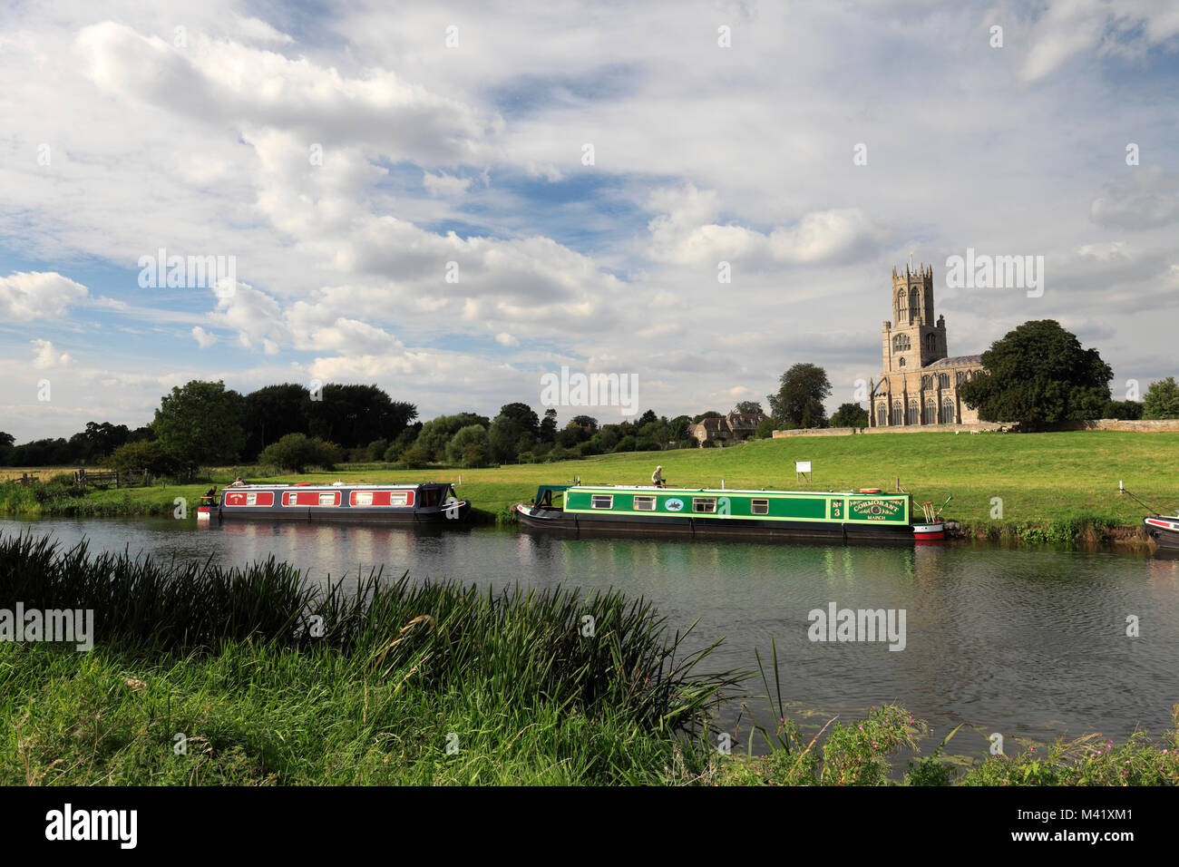 Narrowboats auf dem Fluss Nene; St. Maria und alle Heiligen Kirche; Fotheringhay Dorf; Northamptonshire, England, Großbritannien Stockfoto