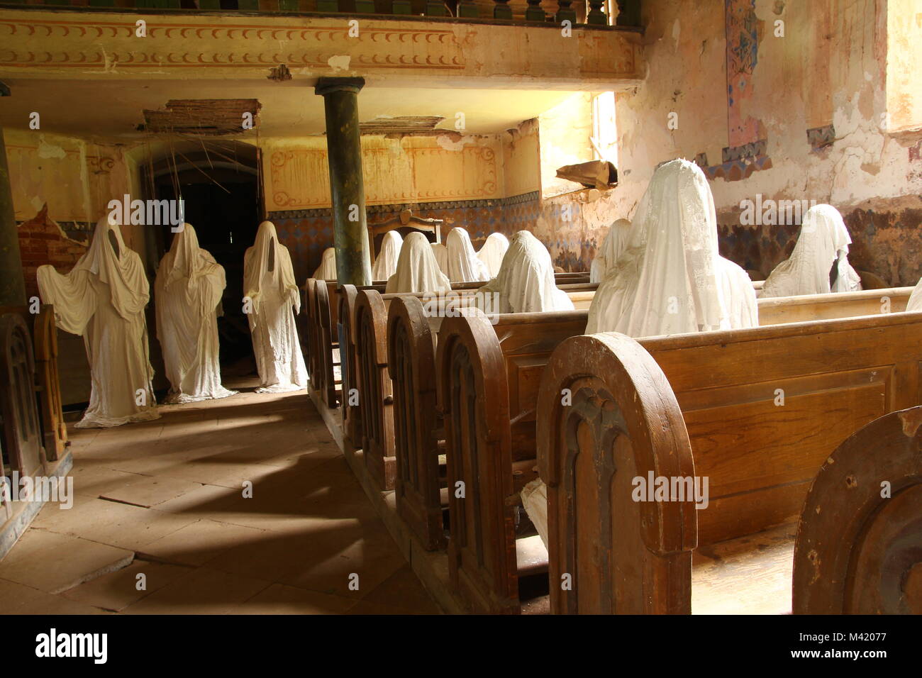 Das Bild aus dem Innenraum der alten, verlassenen, fast zerstörte Kirche in der Tschechischen Republik. Im Inneren sind die Statuen der Gläubigen Geister. Stockfoto