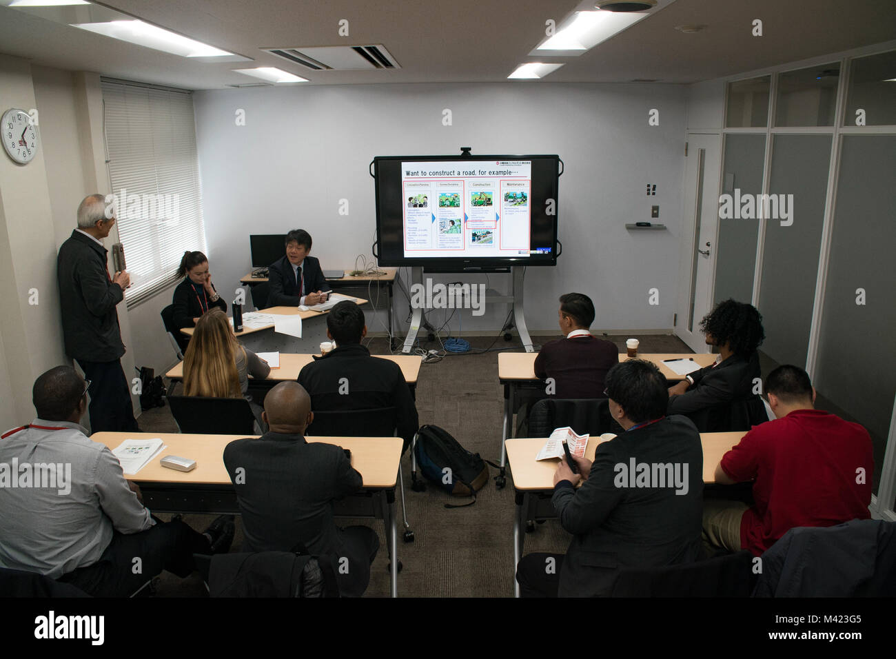 Makoto Takemoto, Manager der Stadtentwicklung Abteilung mit Chuden Engineering Consultants (CEC), gibt eine Präsentation zu einer Gruppe amerikanischer Besucher aus dem Marine Corps Air Station Iwakuni, Japan, die im Betrieb des CEC in Hiroshima, 8. Februar, 2018. Die Verteidigungspolitik Review Initiative (Dpri) festgelegt, ein Tag mit CEC Ihre erste amerikanische Besucher, die fünf Matthew C. Perry High School Studenten, Mitarbeiter und eine dpri Matthew C. Perry Lehrer, für einen Rundgang durch das Gebäude und mit ihren Angestellten zu besuchen und zu sehen, wie sie funktionieren als Host. (U.S. Marine Corps Foto von Sgt. Donato Maffin) Stockfoto