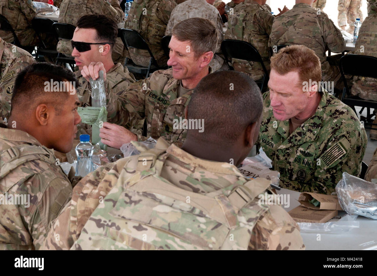 Special Operations Command Central Command (SOCCENT) Sergeant Major, Command Sgt. Maj. Mark W. Eckard, und Fleet Master Chief U.S. Naval Forces Central Command (NAVCENT), Fleet Master Chief Russel Mason, Essen ein Mittagessen der Mahlzeiten, bereit zu Essen mit Soldaten aus dem 2. gepanzerte Brigade Combat Team, 1. Panzerdivision, am Lager Buehring, Kuwait, Feb 9, 2018, während Armee Tag. Armee Tag war die Auftaktveranstaltung für US Central Command der Komponente Kommandeure Konferenz, die US-Army Central die Fähigkeiten der Armee Showcase im Theater auf. (U.S. Armee Foto von Sgt. David L. Nye, USARCENT Stockfoto