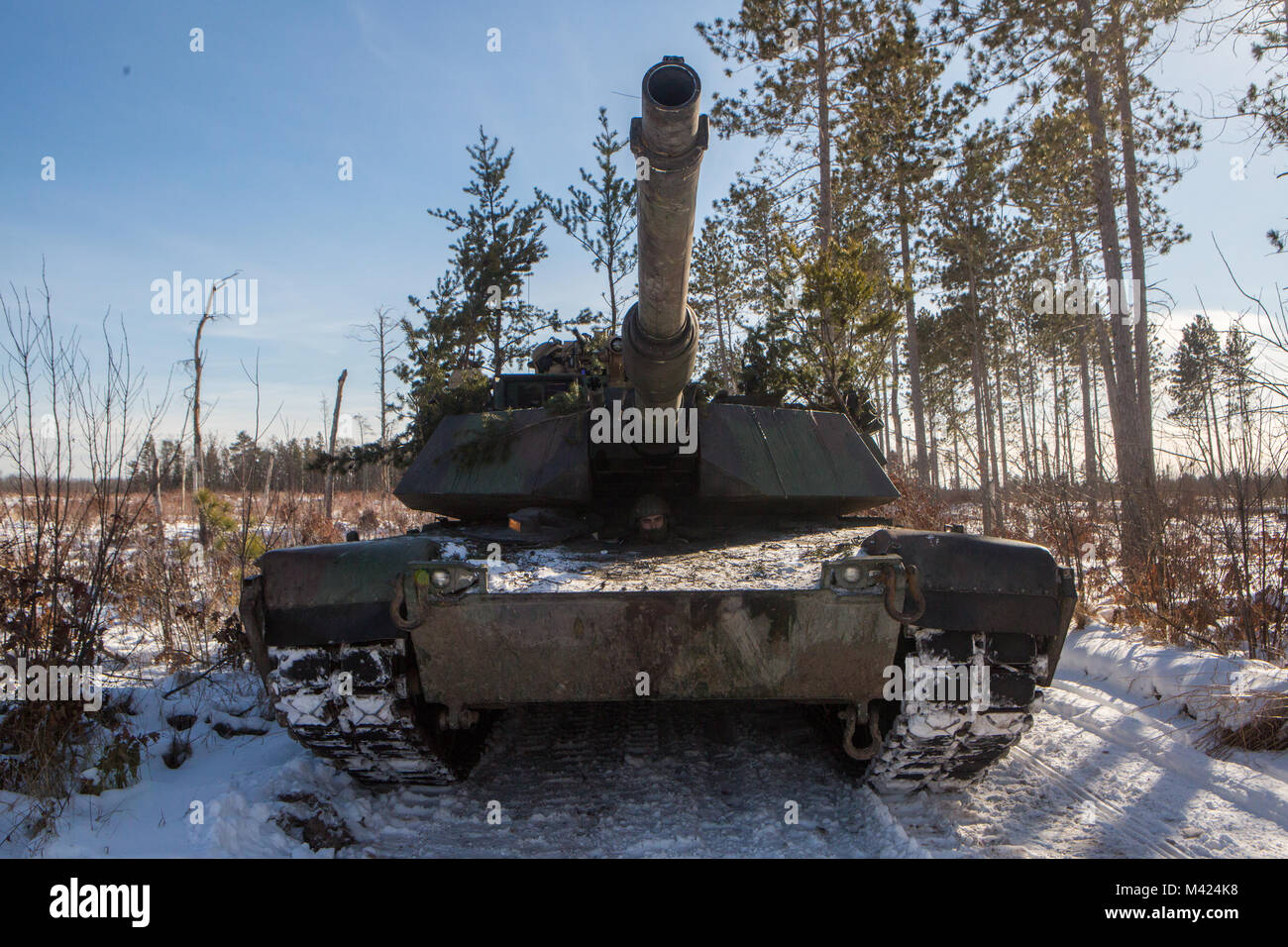 Buchen Marine Lance Cpl. Meilen Bernard, ein Lader und Treiber für Unternehmen F, 4th Tank Battalion, 4th Marine Division, wartet, bevor Rangieren ein ABRAMS M1A1 Main Battle Tank zu einem Kraftstoff resupply Station während der Übung Kurzurlaub im Winter 2018, in der Nähe von Camp Äsche, Michigan, 10.02.2018. Finden Marines verbringen zwei Wochen jedes Jahr bauen ihre Fähigkeiten bei einem jährlichen Übung. Dieses Jahr, das Camp Lejeune in North Carolina, Tank Gesellschaft nutzt weiterhin die Vorteile der robusten Training Camp Äsche Bereichen ihre Offensive, defensive und Manöver Fähigkeiten zu testen, eine strenge Kälte envi Stockfoto