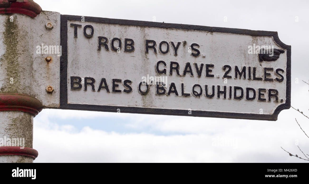 Reisende in Richtung fingerpost Zeichen Regie Rob Roy's Grab, Balquhidder, Perthshire, Schottland, Großbritannien. Stockfoto
