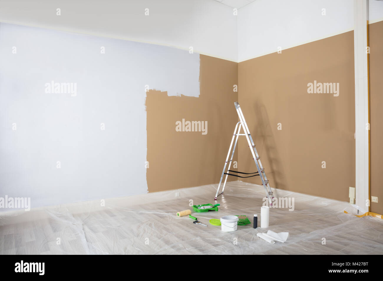 Die Hälfte weiß lackiert Wand mit Leiter und Malerei Ausrüstungen zu Hause Stockfoto