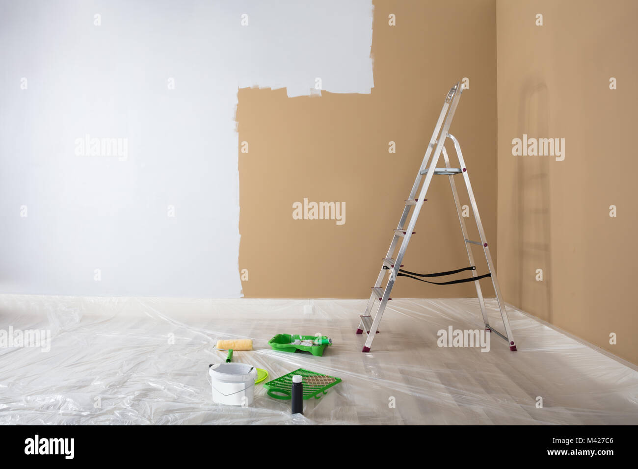 Die Hälfte weiß lackiert Wand mit Leiter und Malerei Ausrüstungen zu Hause Stockfoto