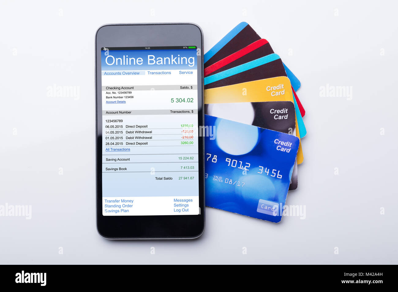Hohe Betrachtungswinkel von Mobilephone mit Online Banking App und Kreditkarte auf weißem Hintergrund Stockfoto