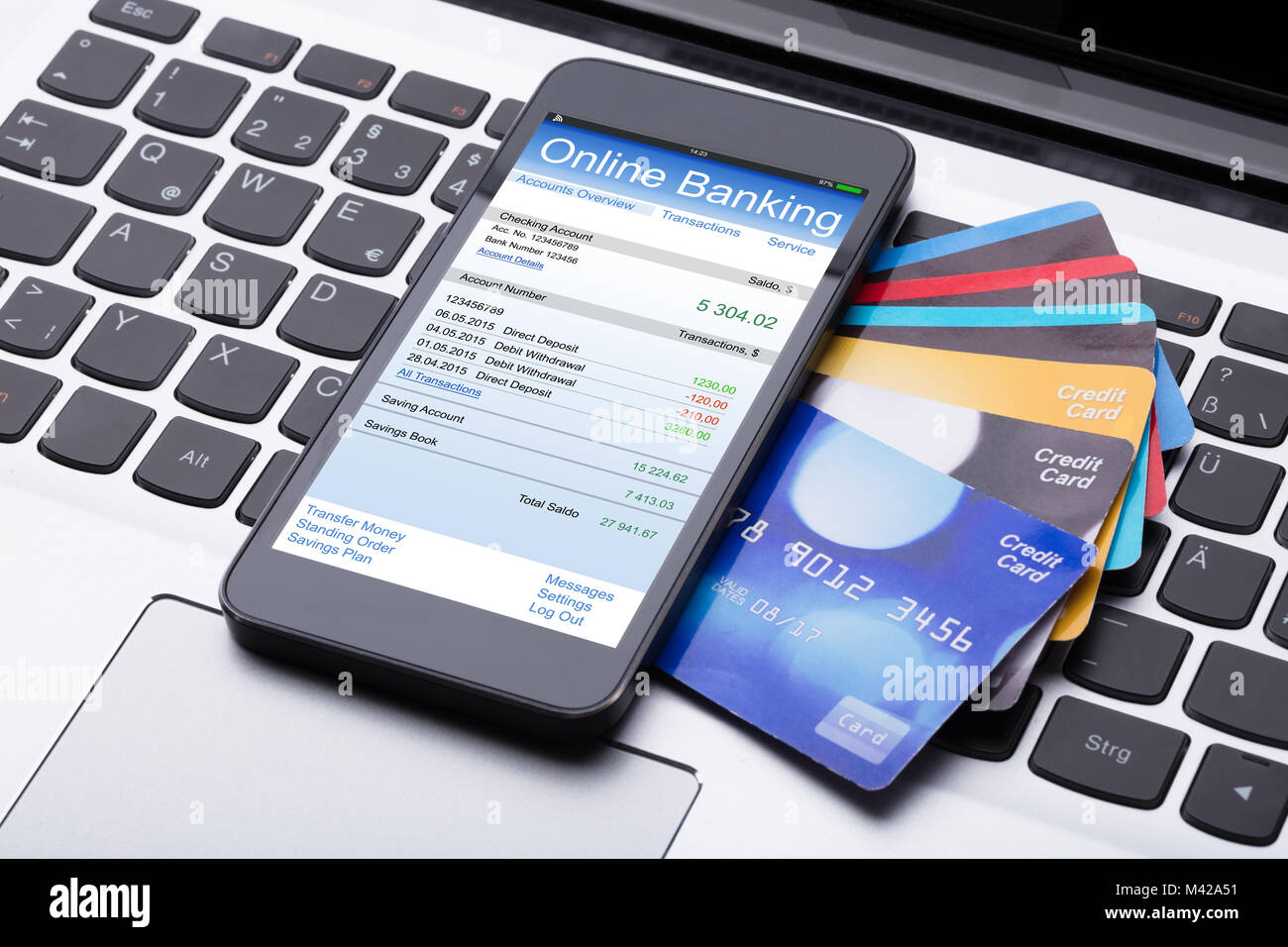 Close-up Handy mit Online Banking App und Kreditkarten auf dem Computer Tastatur Stockfoto