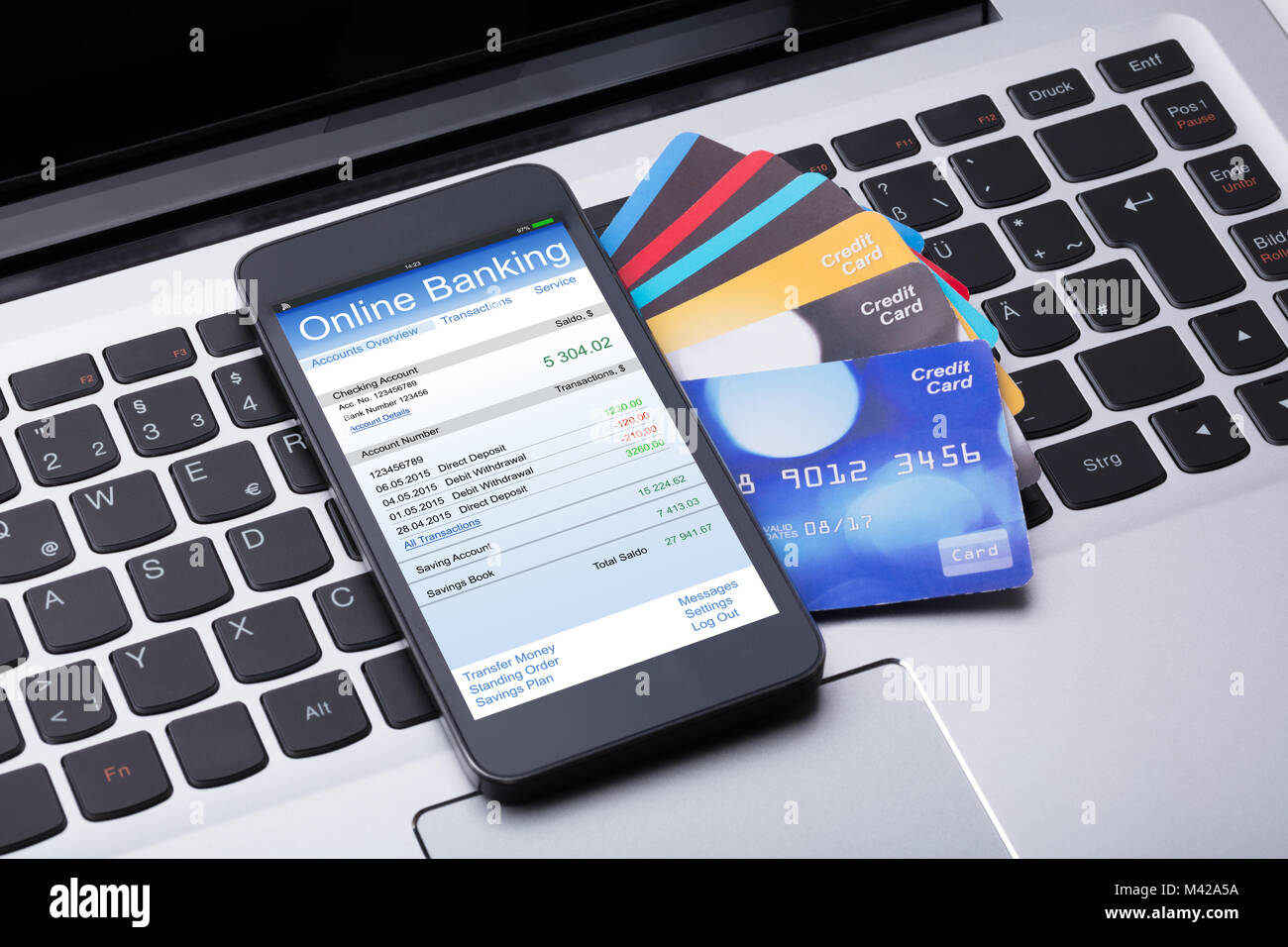 Close-up Handy mit Online Banking App und Kreditkarten auf dem Computer Tastatur Stockfoto