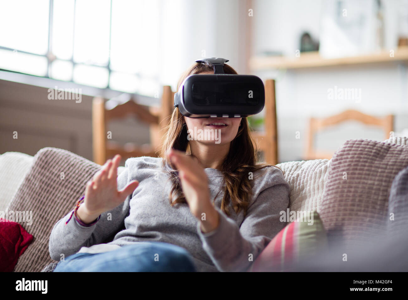 Junge erwachsene Frau mit VR-Headset Stockfoto