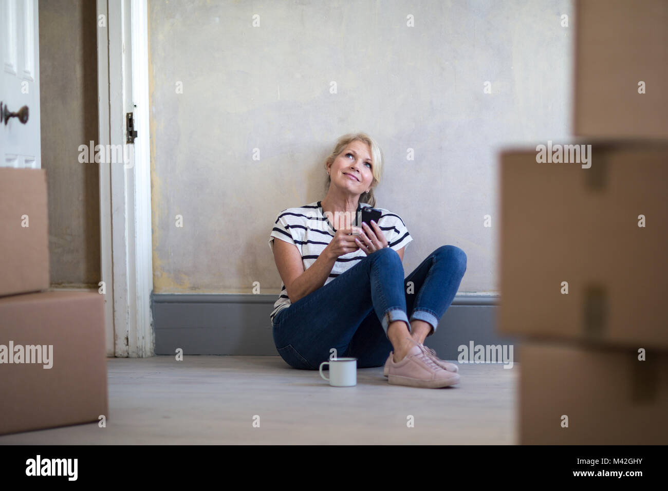 Reife Frauen sitzen mit beweglichen Kästen Stockfoto