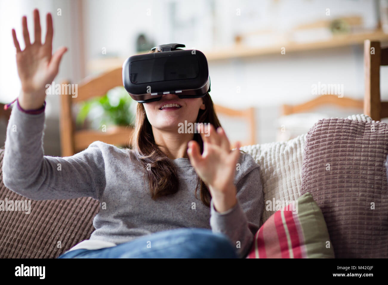 Junge erwachsene Frau mit VR-Headset Stockfoto