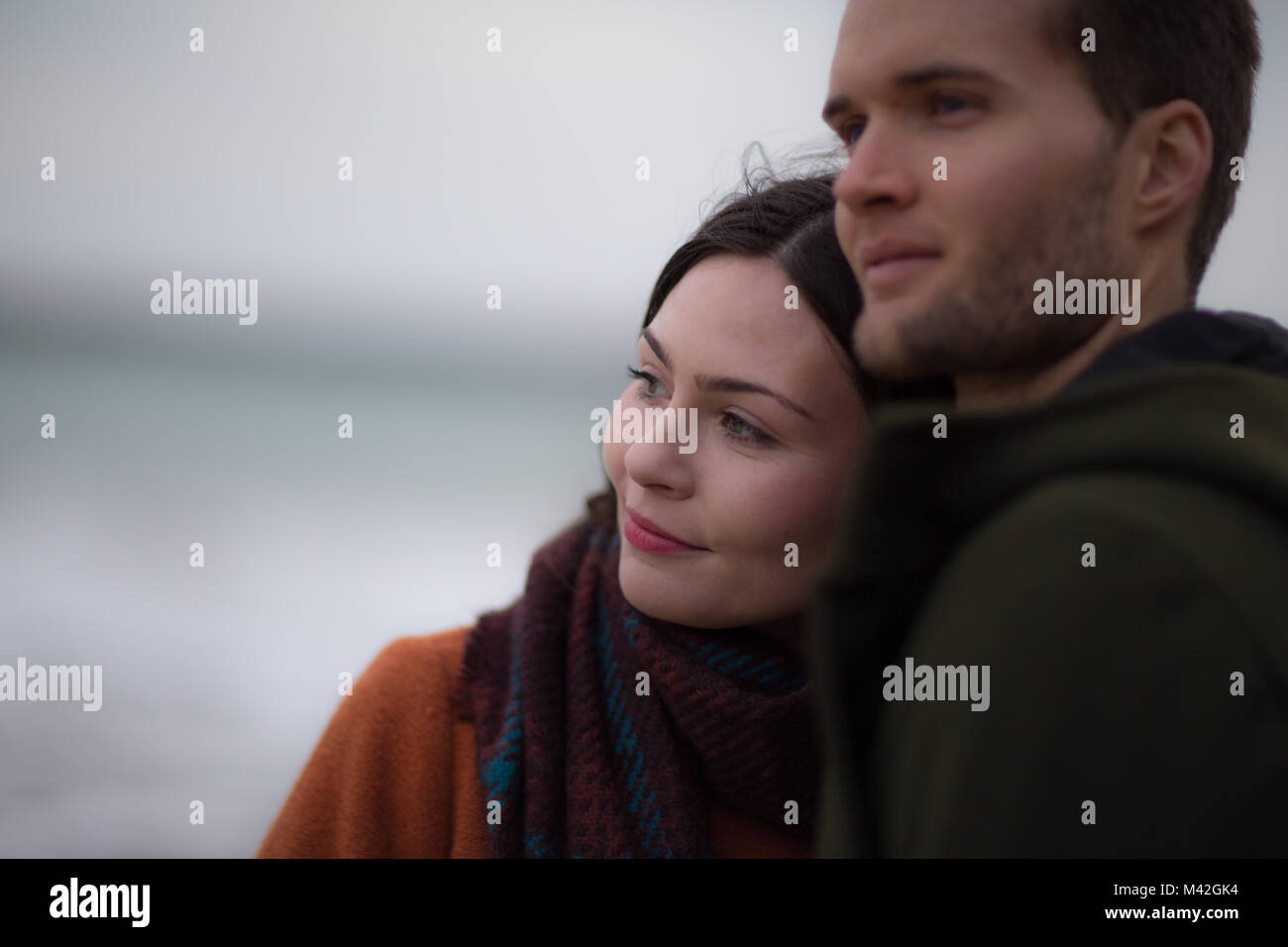 Junge erwachsene Paare auf Winter Strand Stockfoto