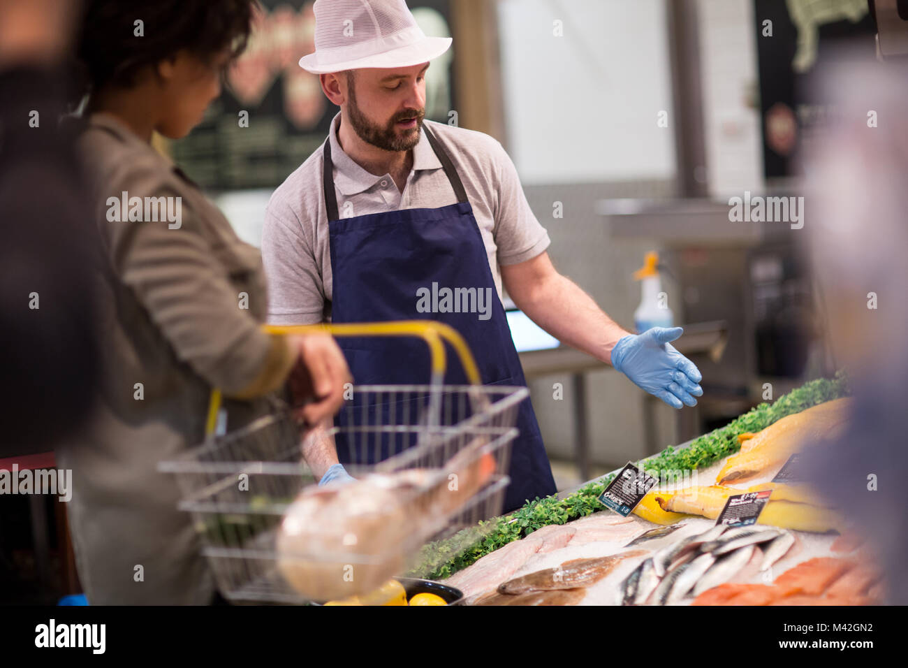 Kunde fragt Fischhändler für Beratung Stockfoto