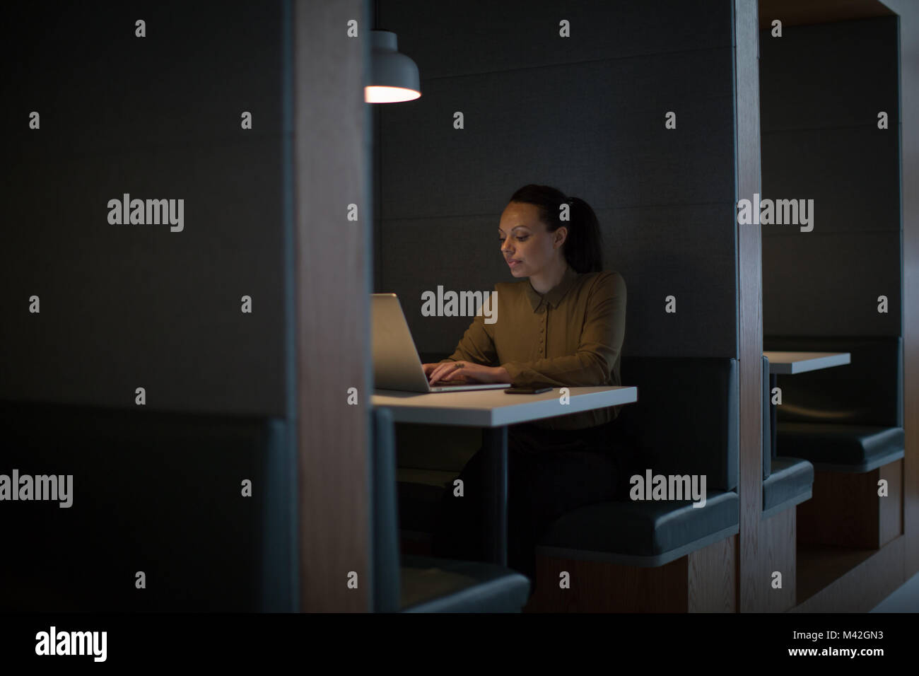 Geschäftsfrau, die spät in der Nacht im Büro allein Stockfoto