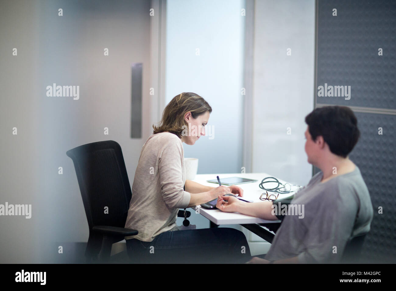 Weibliche Arzt einen übergewichtigen Patienten Blutdruck Stockfoto