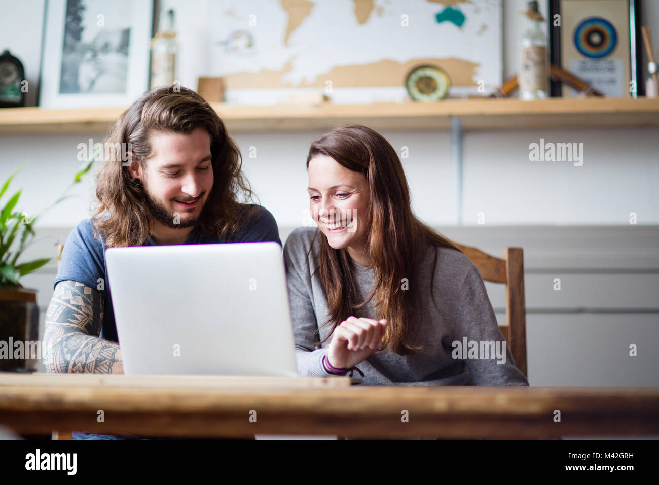 Junge erwachsene Paare mit einem Laptop zusammen Stockfoto